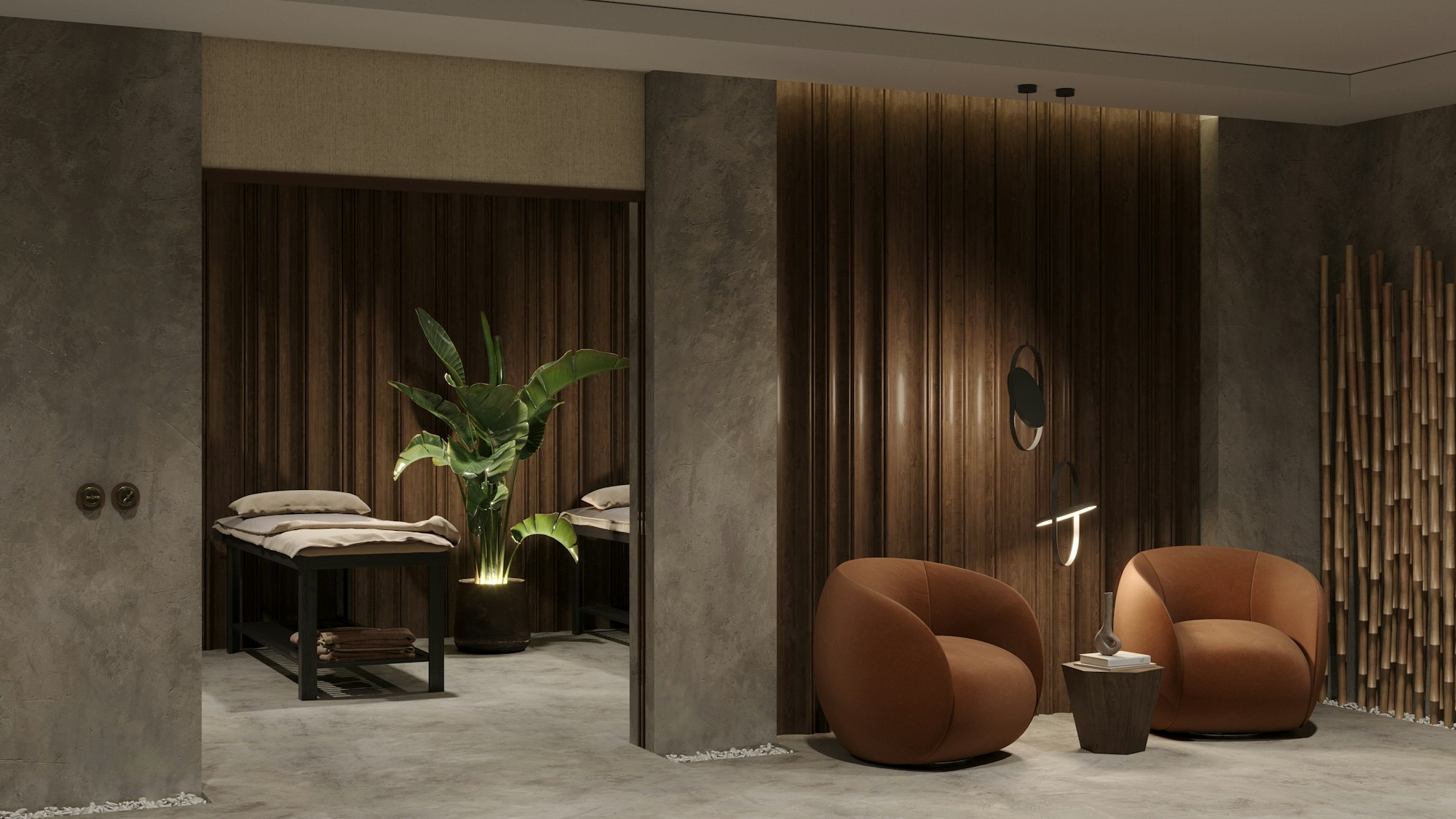 Softly lit spa suite with a treatment bed, a tall potted plant and two rust-colored armchairs